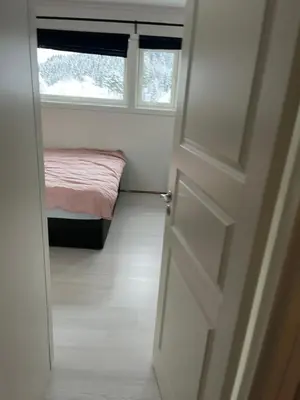 a door to a bedroom with a bed and a window at Ski VM in Trondheim