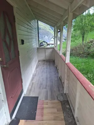 an empty porch of a house with a red door at Jordamorstova in Aurland