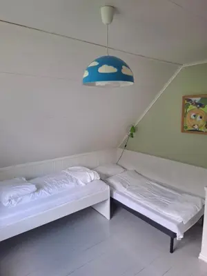 two beds in a room with a pendant light at Jordamorstova in Aurland