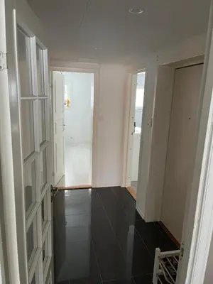 a room with white walls and a hallway with black floors at Trondheim in Trondheim