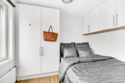 a white bedroom with a bed and white cabinets at Penthouse in Trondheim, Solsiden in Trondheim