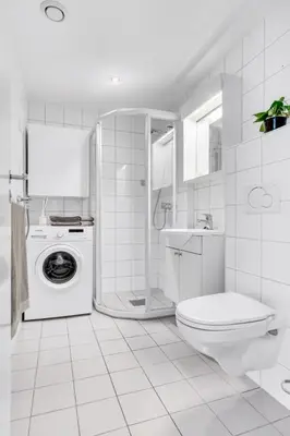a white bathroom with a toilet and a washing machine at Penthouse in Trondheim, Solsiden in Trondheim