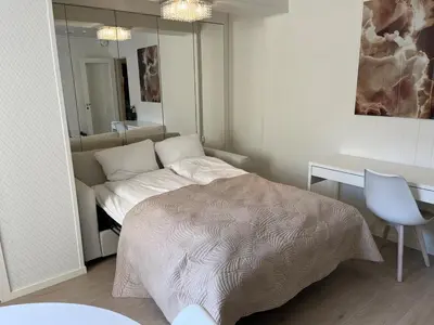 a bedroom with a bed and a desk and a mirror at Apartment by Torgalmenningen in Bergen