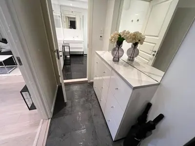 a white kitchen with vases with flowers on a counter at Apartment by Torgalmenningen in Bergen