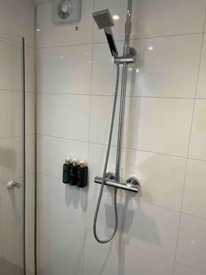 a shower with a shower head in a bathroom at Apartment by Torgalmenningen in Bergen