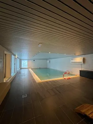 an empty room with a pool in the middle of it at Voss Apartment in Oppheim Resort, pool and view in Vossevangen