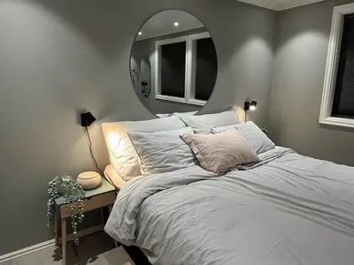 a bedroom with a large bed with a mirror at Enebolig til utleie in Trondheim