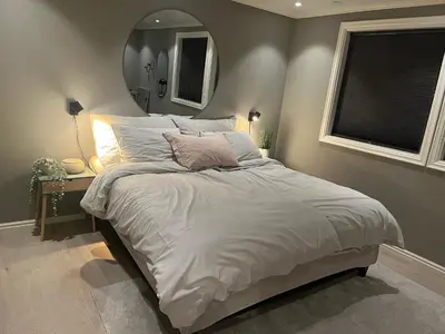 a bedroom with a large bed with a mirror at Enebolig til utleie in Trondheim