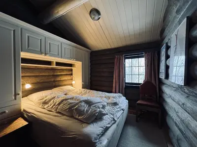 a bedroom with a bed and a chair and a window at Large, cozy, and spacious cabin in Geilo in Geilo