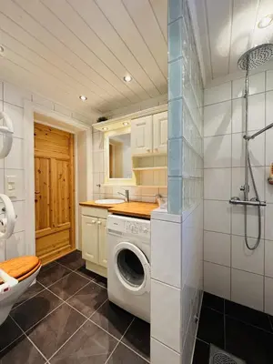 a bathroom with a washing machine and a sink at Large, cozy, and spacious cabin in Geilo in Geilo