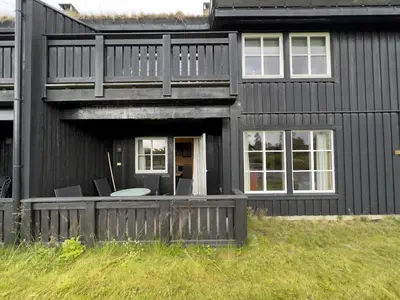 a black house with a porch and chairs in it at Family-Friendly Apartment In Central Beitostølen in Beitostøl