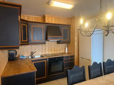 a kitchen with wooden cabinets and a stove top oven at Family-Friendly Apartment In Central Beitostølen in Beitostøl