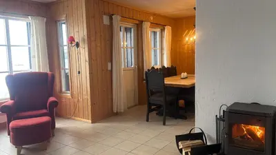 a living room with a fireplace and a table and a chair at Family-Friendly Apartment In Central Beitostølen in Beitostøl