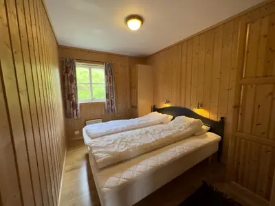 a bedroom with a bed in a room with wooden walls at Family-Friendly Apartment In Central Beitostølen in Beitostøl