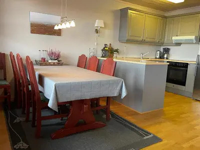 a kitchen with a table with red chairs and a sink at Family-Friendly Stay Near Ski Trails! in Beitostøl