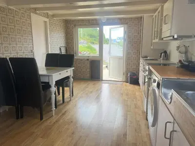 a kitchen with a table with chairs and a table at Fiskesenter Birkeland Guesthouse in Vestnes