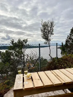 two glasses of wine sitting on a wooden table at Cozy studio near Bergen in Bergen