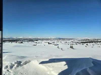 a shadow of a person standing in a snow covered field at Varden in Sør-Fron