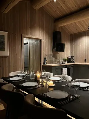 a dining room with a table and chairs and a kitchen at Varden in Sør-Fron