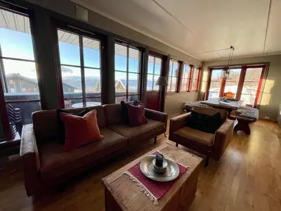 a living room with a couch and chairs and windows at Charming 2-Bedroom Apartment In Beitostølen in Beitostøl