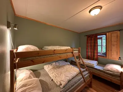 a room with three bunk beds and a window at Central Apartment With Garage, Views, Ski In And Out in Beitostøl