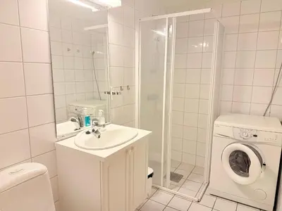 a bathroom with a sink and a washing machine at Central Apartment With Garage, Views, Ski In And Out in Beitostøl