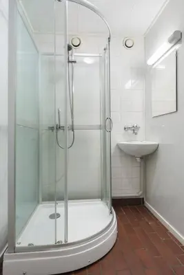 a bathroom with a shower and a sink at 1-roms leiligheter med felles bad, stue og kjøkken in Steinkjer
