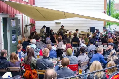 a large group of people sitting at tables in a crowd at Nice two-floor home by Gamle bybro in Trondheim