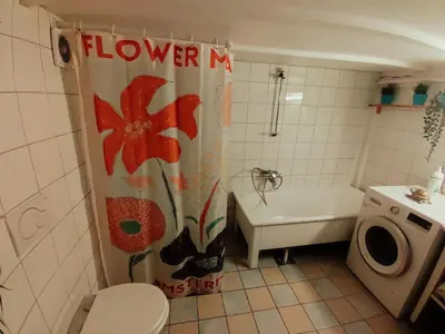 a bathroom with a shower curtain with a flower on it at Nice two-floor home by Gamle bybro in Trondheim