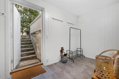 a white room with a staircase and a mirror at Apartment in Lillehammer in Lillehammer