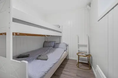 a white bedroom with a bunk bed and a table at Apartment in Lillehammer in Lillehammer