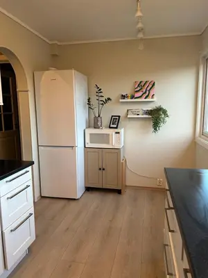 a kitchen with a white refrigerator and a counter at Horizontal half at Byaasen in Trondheim