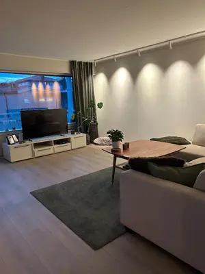 a living room with a couch and a flat screen tv at Horizontal half at Byaasen in Trondheim