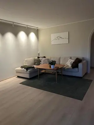 a living room with a couch and a table at Horizontal half at Byaasen in Trondheim