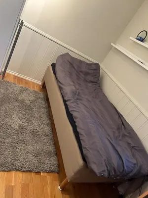 a bed in a corner of a room at Horizontal half at Byaasen in Trondheim