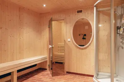 a sauna with a shower and a mirror at Solheimen konferansehotell AS in Hedalen