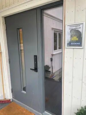 a glass door to a house with a sign on it at Trollstova in Sogndal