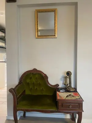 a green couch sitting next to a table with a mirror at Trollstova in Sogndal