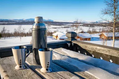 a water bottle and two cups on a wooden table at Hytteperle Gålå, Vakre Lauvåsen, Hønhuset in Sør-Fron