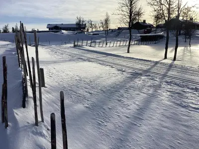 a snow covered field with trees and a fence at Hytteperle Gålå, Vakre Lauvåsen, Hønhuset in Sør-Fron