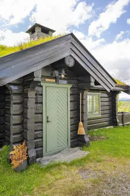 a small log cabin with a green door at Hytteperle Gålå, Vakre Lauvåsen, Hønhuset in Sør-Fron