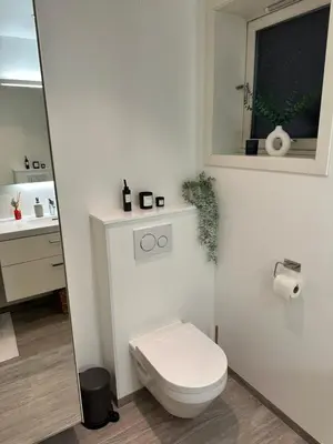 a white bathroom with a toilet and a window at Leilighet på Byåsen, i nærheten av Granåsen in Trondheim