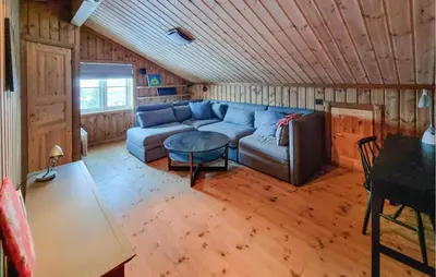 a living room with a blue couch and a table at Gorgeous Home In Vang I Valdres in Vang I Valdres