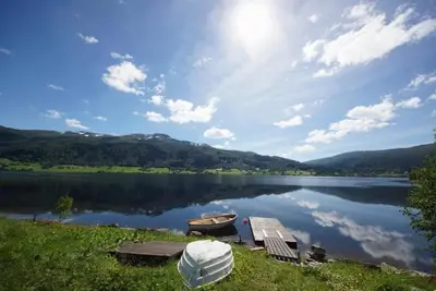 a view of a lake with a boat on a dock at Leilighet på Oppheim, Voss in Vossevangen