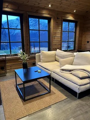 a living room with a couch and a coffee table at Cabin by the fjord in Geiranger