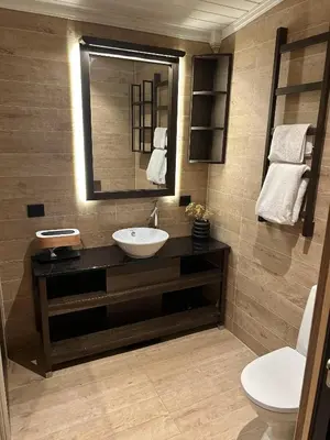 a bathroom with a sink and a mirror and a toilet at Cabin by the fjord in Geiranger