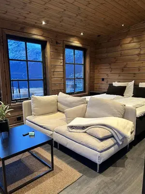 a living room with a couch and two beds at Cabin by the fjord in Geiranger