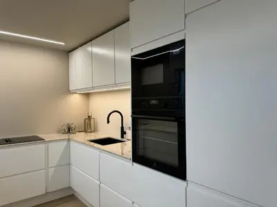 a kitchen with white cabinets and black appliances at Modern Home with a View, Easy access to World Ski Championships in Malvik