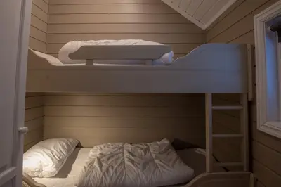 a bunk bed with a ladder and a bunk bed in a room at Bakkebyvegen 15B in Trysil