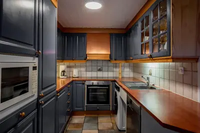 a kitchen with blue cabinets and wooden counter tops at Bakkebyvegen 15A in Trysil